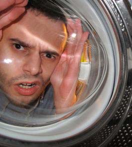 A man looks inside the washing machine's drum