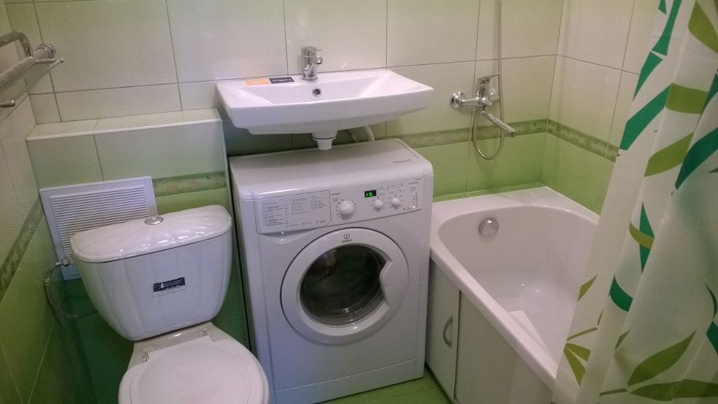washing machine next to the bathroom