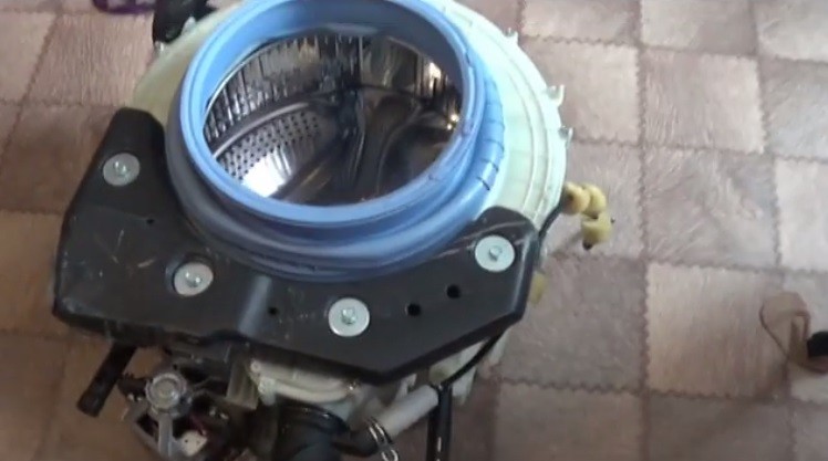 we take out the tank with the drum and unscrew the screws