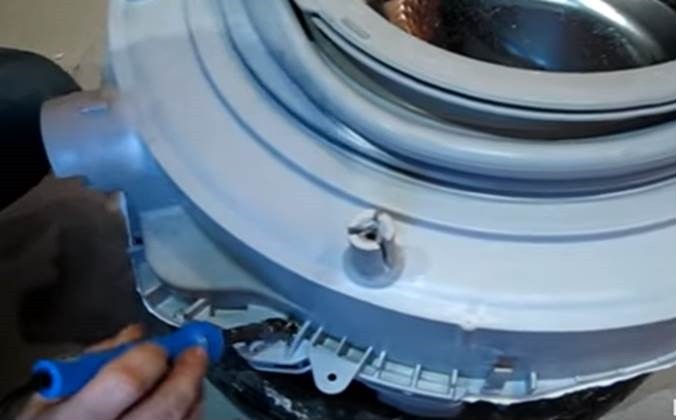 Using a soldering iron, we make recesses for the screws in the edge of the tank