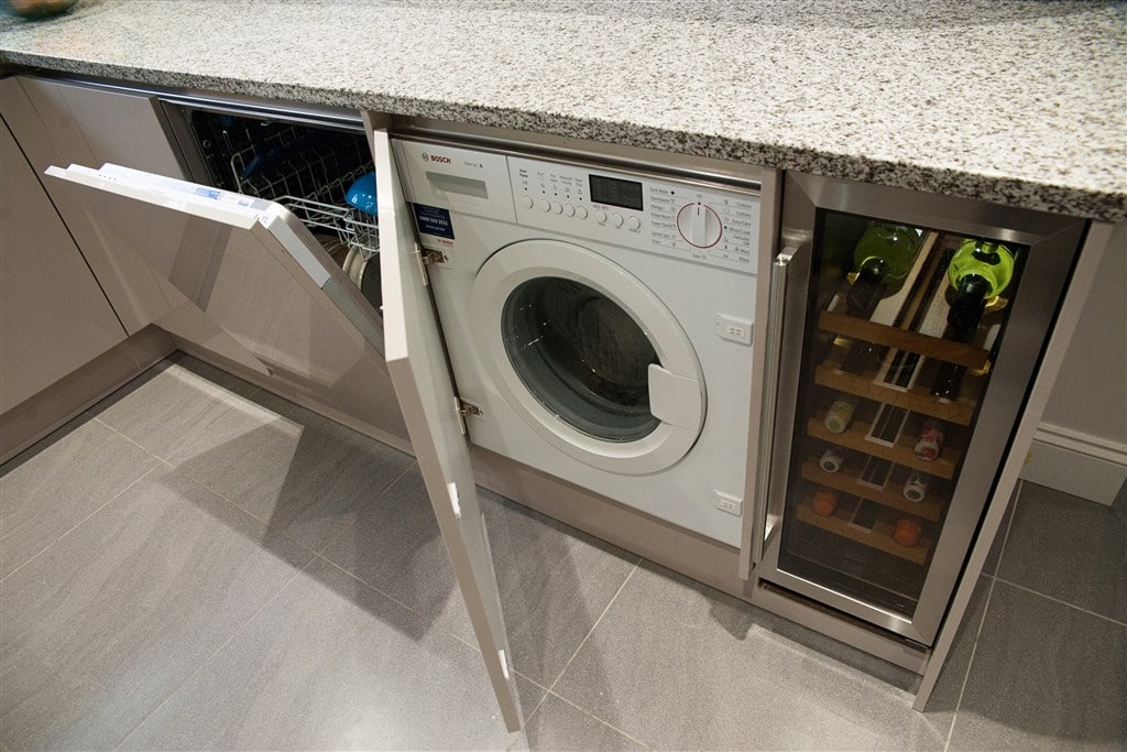 a washing machine in the kitchen cabinet