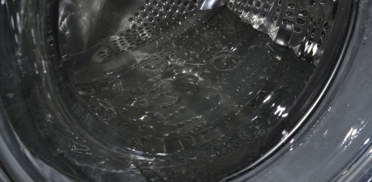 We scoop out water from the machine by opening the hatch