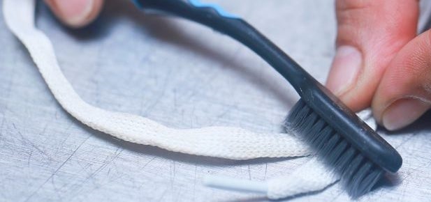 cleaning shoelaces with a brush