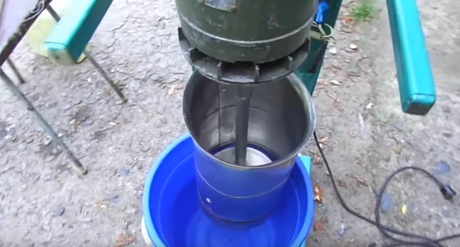 The shaft rotates, spins the disk, and apple pieces fall into the bucket.