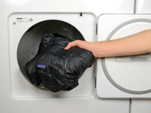 What setting should I use to dry a down jacket in a tumble dryer?