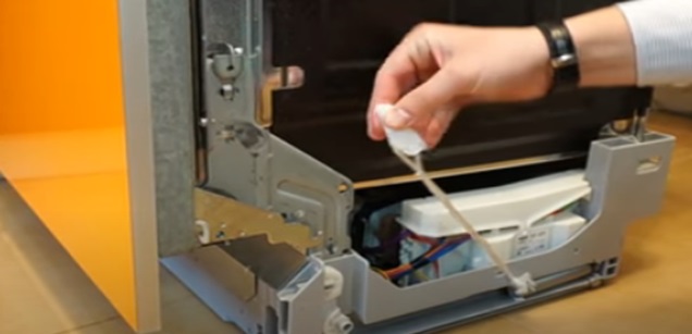 We pull the tensioner cables of the dishwasher door opening