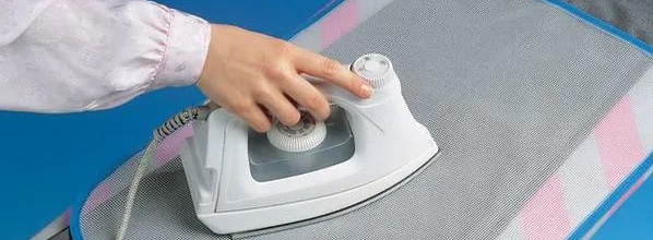 ironing a woolen item through gauze